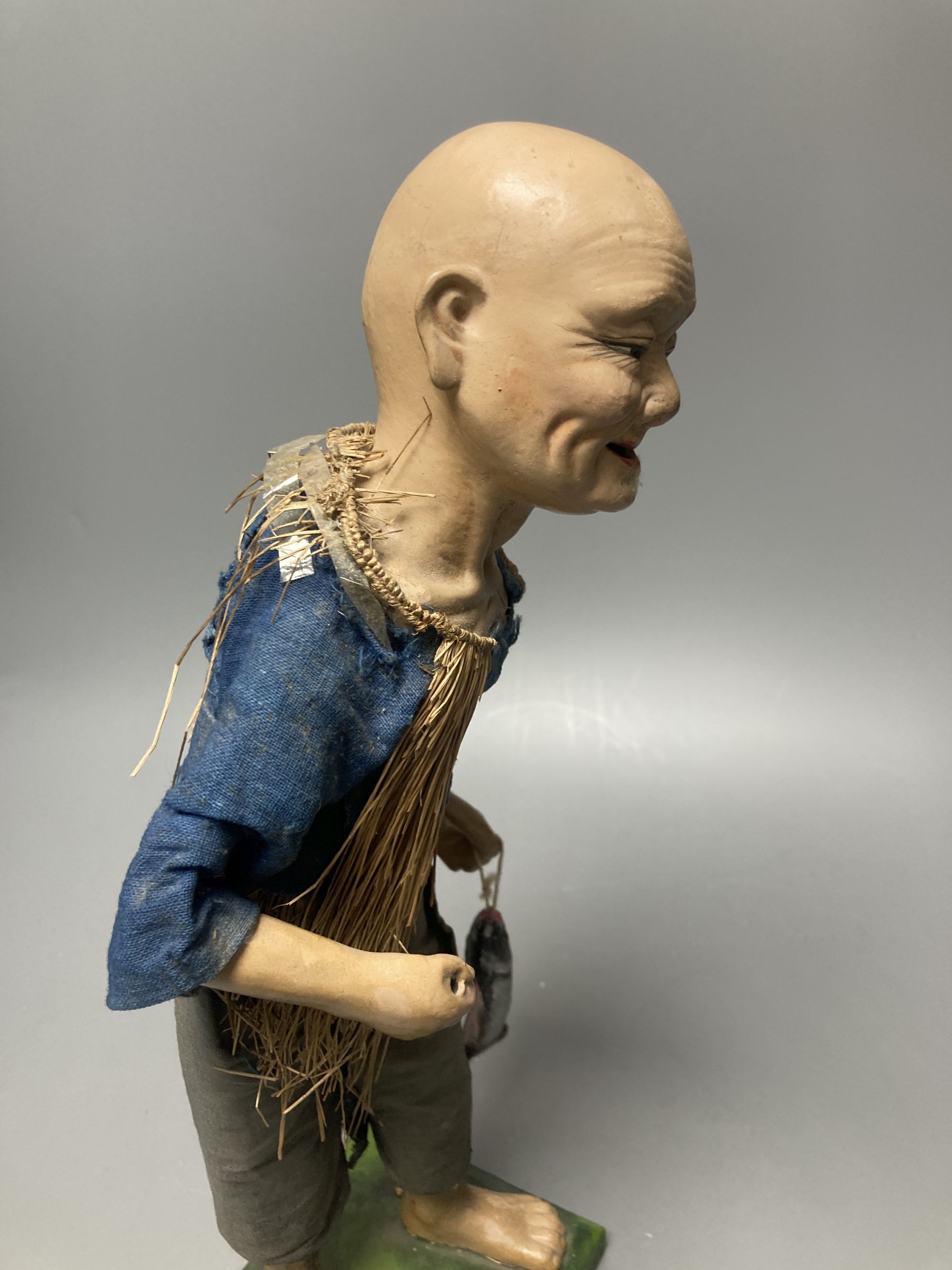 An early 20th century Chinese painted composition figure of a fisherman